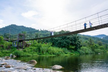 Nakhon Si Thamma, Tayland - 6 Ekim 2024: Turistler Tayland 'ın Nakhon si thammarat kentindeki Kiriwong köyündeki Askı Köprüsü' nde yürüyorlar