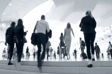 Bulanık bir geçmişi olan modern bir iş merkezinin lobisindeki insanların soyut görüntüleri.