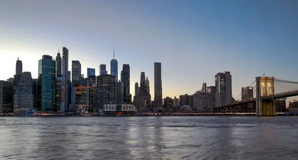 パノラマビューニューヨークのダウンタウンマンハッタンの高層ビルやブルックリン橋と夜のスカイライン ロイヤリティフリーのストック写真