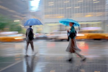 Yağmurlu bir günde sokakta yürüyen iş adamları bulanıklaştı