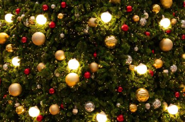Noel ağacı. Ampul ve altın noel baloları Noel ağacını süslüyor. Mutlu Noeller ve yeni yıl tatili geçmişi.