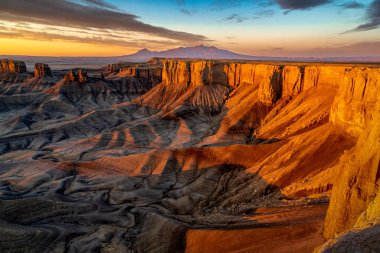 Hanksville yakınlarındaki Utah çölündeki Moonscape Overlook 'da dramatik renkli bir gün doğumu. Henry Dağları uzaktan aydınlatılıyor..