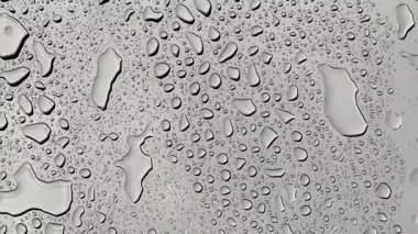 Yağmur yağarken cam yüzeyde 4K su damlacıkları