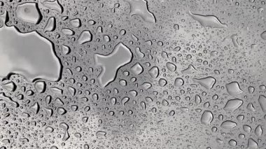 Yağmur yağarken cam yüzeyde 4K su damlacıkları