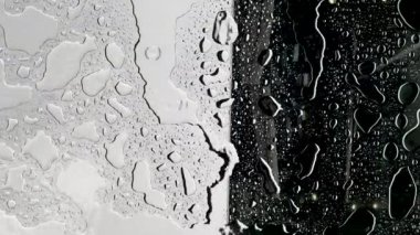 Yağmur yağarken cam yüzeyde 4K su damlacıkları