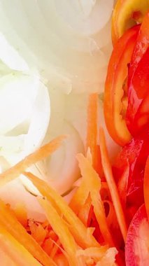 İnce dilimlenmiş havuç, kiraz domatesleri, dilimlenmiş kırmızı domates, yeşil (muhtemelen romaine marulu) ve dilimlenmiş sarı dolma biberli parlak ve taze bir salata. Dokuları çok farklı.