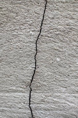 Beton duvar dokusunda görünen çatlak bir yüzey.