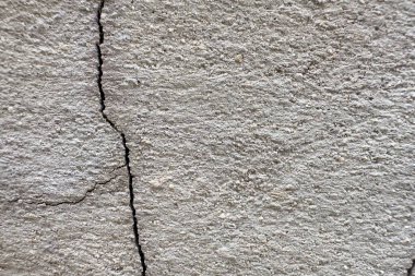 Beton duvar dokusunda görünen çatlak bir yüzey.
