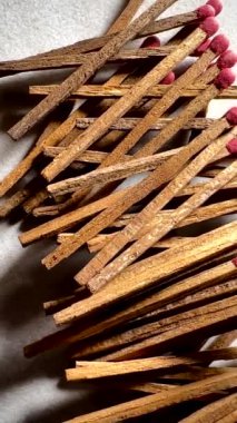 Kırmızı uçlu birkaç kibrit çöpünün yakın çekimi ve pürüzsüz granit bir yüzeye saçılmış çubuklar.