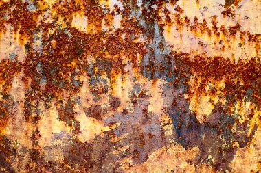 Paslanmış ve çürümüş metale yakın çekim. Yüzeyde hafif turuncu, kahverengi, sarı ve beyaz renkli oksitlenme katmanı vardır. doku ve arkaplan