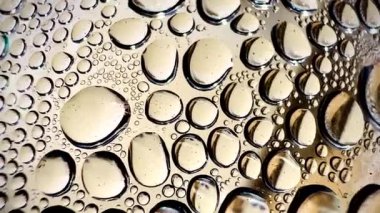 Yansıtıcı yüzeydeki su damlacıklarına yakın çekim. Her damlacık farklı boyutlarda ve eşit dağılmış. doku ve arkaplan