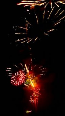 4 bin. Gerçek havai fişeklerin kusursuz döngü arka planında gece gökyüzünde Bokeh ışıkları olan altın havai fişekler. Parlak havai fişek gösterisi. Yeni yıl arifesinde havai fişekler Bangkok 'ta çeşitli renkleri kutluyor