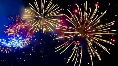 4 bin. Gerçek havai fişeklerin kusursuz döngü arka planında gece gökyüzünde Bokeh ışıkları olan altın havai fişekler. Parlak havai fişek gösterisi. Yeni yıl arifesinde havai fişekler Bangkok 'ta çeşitli renkleri kutluyor