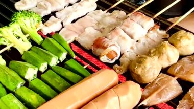 Taze brokoli, domates, sosis, domuz pastırması, balık köftesi ve terbiye edilmiş et gibi sebzeli ızgara ve BBQQQdeğişik türde şiş etler sıcak kömürde pişirmek için mükemmeldir.