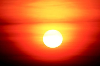 Bu çarpıcı yüksek çözünürlüklü fotoğraf Güneş 'i yakından yakalar, yoğun kırmızı, portakal ve sarıları gösterir. Güneş, karanlık gökyüzünde büyük bir küre olarak belirir. Güneş 'in alt kısmı karanlık ufka karışır..