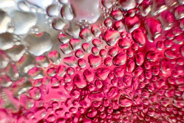 Metal yüzeydeki su damlacıklarının yoğunlaşmasını gösteren yüksek çözünürlüklü su damlalarının yakın çekim görüntüsü. Karmaşık desenler ve farklı boyutlardaki su damlacıkları güzel bir soyut doku oluşturur.. 