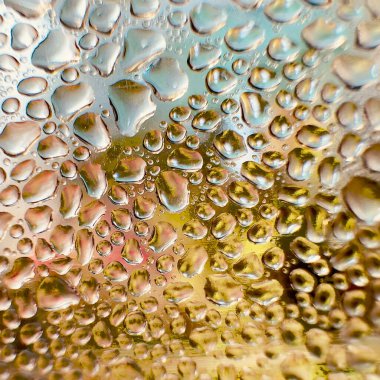 Metal yüzeydeki su damlacıklarının yoğunlaşmasını gösteren yüksek çözünürlüklü su damlalarının yakın çekim görüntüsü. Karmaşık desenler ve farklı boyutlardaki su damlacıkları güzel bir soyut doku oluşturur.. 