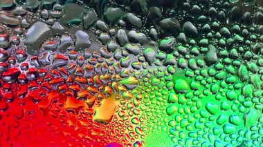 Metal yüzeydeki su damlacıklarının yoğunlaşmasını gösteren yüksek çözünürlüklü su damlalarının yakın çekim görüntüsü. Karmaşık desenler ve farklı boyutlarda su damlacıkları güzel bir soyut oluşturur.