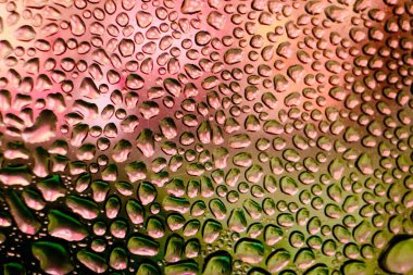 Metal yüzeydeki su damlacıklarının yoğunlaşmasını gösteren yüksek çözünürlüklü su damlalarının yakın çekim görüntüsü. Karmaşık desenler ve farklı boyutlardaki su damlacıkları güzel bir soyut doku oluşturur.. 