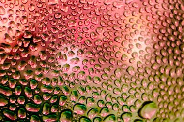 Metal yüzeydeki su damlacıklarının yoğunlaşmasını gösteren yüksek çözünürlüklü su damlalarının yakın çekim görüntüsü. Karmaşık desenler ve farklı boyutlardaki su damlacıkları güzel bir soyut doku oluşturur.. 