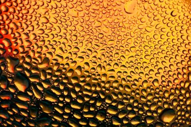 Metal yüzeydeki su damlacıklarının yoğunlaşmasını gösteren yüksek çözünürlüklü su damlalarının yakın çekim görüntüsü. Karmaşık desenler ve farklı boyutlardaki su damlacıkları güzel bir soyut doku oluşturur.. 