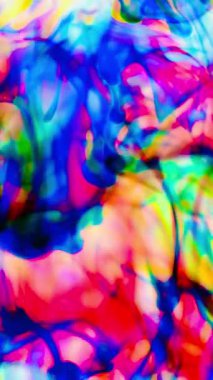 Suya renkli mürekkeplerle akan canlı renklere sahip soyut video. Kompozisyon mavi, kırmızı, yeşil ve sarı tonlarından oluşur. Hafif bir arkaplanda harmanlanır ve kıvrılır.