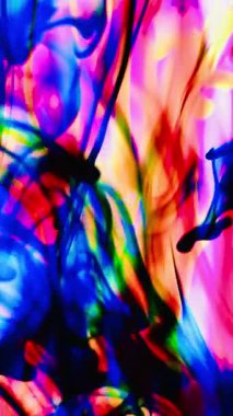 Suya renkli mürekkeplerle akan canlı renklere sahip soyut video. Kompozisyon mavi, kırmızı, yeşil ve sarı tonlarından oluşur. Hafif bir arkaplanda harmanlanır ve kıvrılır.