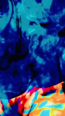 Suya renkli mürekkeplerle akan canlı renklere sahip soyut video. Kompozisyon mavi, kırmızı, yeşil ve sarı tonlarından oluşur. Hafif bir arkaplanda harmanlanır ve kıvrılır.