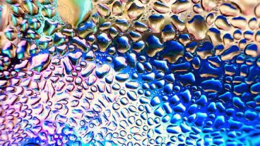 Metal yüzeydeki su damlacıklarının yoğunlaşmasını gösteren yüksek çözünürlüklü su damlalarının yakın çekim görüntüsü. Karmaşık desenler ve farklı boyutlarda su damlacıkları güzel bir soyut oluşturur.