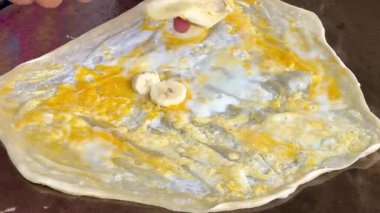 4k Street yiyecek satıcısı hamur ve tavada kızartılmış paratha roti 'yi dışarıda çıtır çıtır olana kadar kızgın yağda hazırlıyor. Sokak işportacısı sabah kahvaltısı için prata ekmeği veya roti canai hazırlıyor.