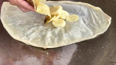 4k Street yiyecek satıcısı hamur ve tavada kızartılmış paratha roti 'yi dışarıda çıtır çıtır olana kadar kızgın yağda hazırlıyor. Sokak işportacısı sabah kahvaltısı için prata ekmeği veya roti canai hazırlıyor.