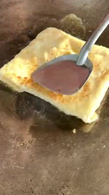 4k Street yiyecek satıcısı hamur ve tavada kızartılmış paratha roti 'yi dışarıda çıtır çıtır olana kadar kızgın yağda hazırlıyor. Sokak işportacısı sabah kahvaltısı için prata ekmeği veya roti canai hazırlıyor.