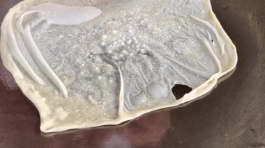4k Street yiyecek satıcısı hamur ve tavada kızartılmış paratha roti 'yi dışarıda çıtır çıtır olana kadar kızgın yağda hazırlıyor. Sokak işportacısı sabah kahvaltısı için prata ekmeği veya roti canai hazırlıyor.