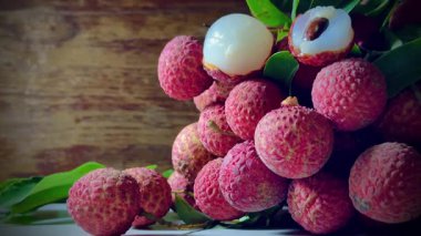 Ağaçtan sarkan bir avuç olgun liçi. Lychees 'ler sert, pullu derilerle parlak kırmızı renktedir. Bu da olgun ve hasat için hazır olduklarını gösterir. Lychees bir yiyecek ve meyvedir..