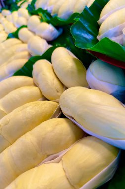 Yeşil bir muz yaprağına düzgünce yerleştirilmiş taze olgun durian parçaları var. Durian 'ın her parçası beyaz balmumu kağıdıyla dikkatlice altına sarılmış. En iyi Tayland meyvesi..