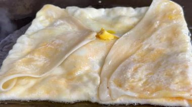 4k Street yiyecek satıcısı hamur ve tavada kızartılmış paratha roti 'yi dışarıda çıtır çıtır olana kadar kızgın yağda hazırlıyor. Sokak işportacısı sabah kahvaltısı için prata ekmeği veya roti canai hazırlıyor.