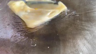 4k Street yiyecek satıcısı hamur ve tavada kızartılmış paratha roti 'yi dışarıda çıtır çıtır olana kadar kızgın yağda hazırlıyor. Sokak işportacısı sabah kahvaltısı için prata ekmeği veya roti canai hazırlıyor.