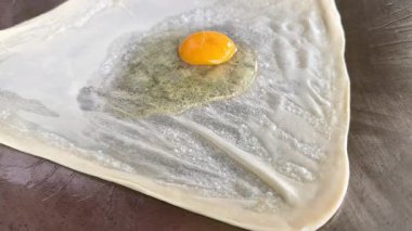 4k Street yiyecek satıcısı hamur ve tavada kızartılmış paratha roti 'yi dışarıda çıtır çıtır olana kadar kızgın yağda hazırlıyor. Sokak işportacısı sabah kahvaltısı için prata ekmeği veya roti canai hazırlıyor.