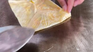 4k Street yiyecek satıcısı hamur ve tavada kızartılmış paratha roti 'yi dışarıda çıtır çıtır olana kadar kızgın yağda hazırlıyor. Sokak işportacısı sabah kahvaltısı için prata ekmeği veya roti canai hazırlıyor.