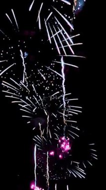 4 bin. Gerçek havai fişeklerin kusursuz döngü arka planında gece gökyüzünde Bokeh ışıkları olan altın havai fişekler. Parlak havai fişek gösterisi. Yeni yıl arifesinde havai fişekler birden fazla rengi kutluyor. 