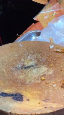 Ahşap kesme tahtasının üzerinde kızarmış tavuk doğrayan bir şefin yakın çekimi. Bangkok 'ta sokak yemeği.