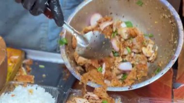 Bangkok 'ta pilavın üstünde kızarmış tavuk servis eden bir şefin yakın çekimi..