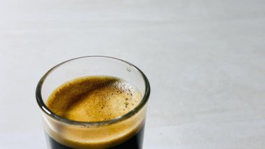 Barista dipsiz kabın içinde kahve tozu hazırlıyor ve kahve tozunu bozuyor..