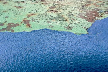 Çürümüş metal yüzeyinde mavi ve pas lekeleri olan eski kabuklu yeşil boya, arka plan ve grunge tasarımı için mükemmel..