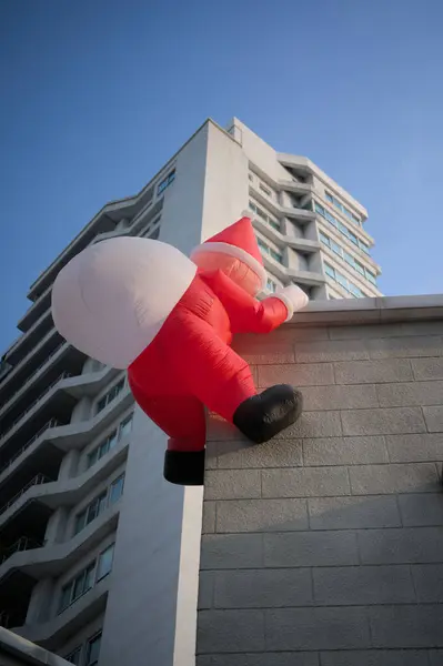 Noel Baba balonu bir binaya tırmanıyor.