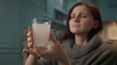 Kadın migrenden muzdarip. Evde ağrı kesici içen bir kadın. Hasta kadın baş ağrısından ilaç alıyor. 4K