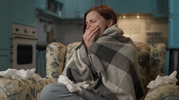 家で風邪をひいた病気の女性 30代の女性がソファで暖まるために毛布に包まれた アパートで暖房がない — ストック動画