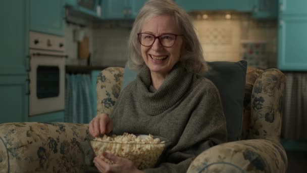 Dojrzała Kobieta Oglądająca Telewizję Jedzącą Popcorn Starsza Pani Śmieje Się — Wideo stockowe