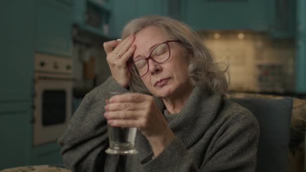 Yaşlı Kadın Migrenden Muzdarip Yaşlı Kadın Evde Oturup Ilaç Alıyor — Stok video