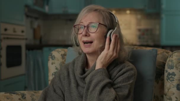 Старшая Женщина Слушает Музыку Дома Пожилая Леди Наслаждается Своей Любимой — стоковое видео